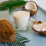 Coconut opened, coconut water and milk flatlay
